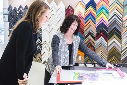custom framing consultant working on choosing mouldings for custom frames